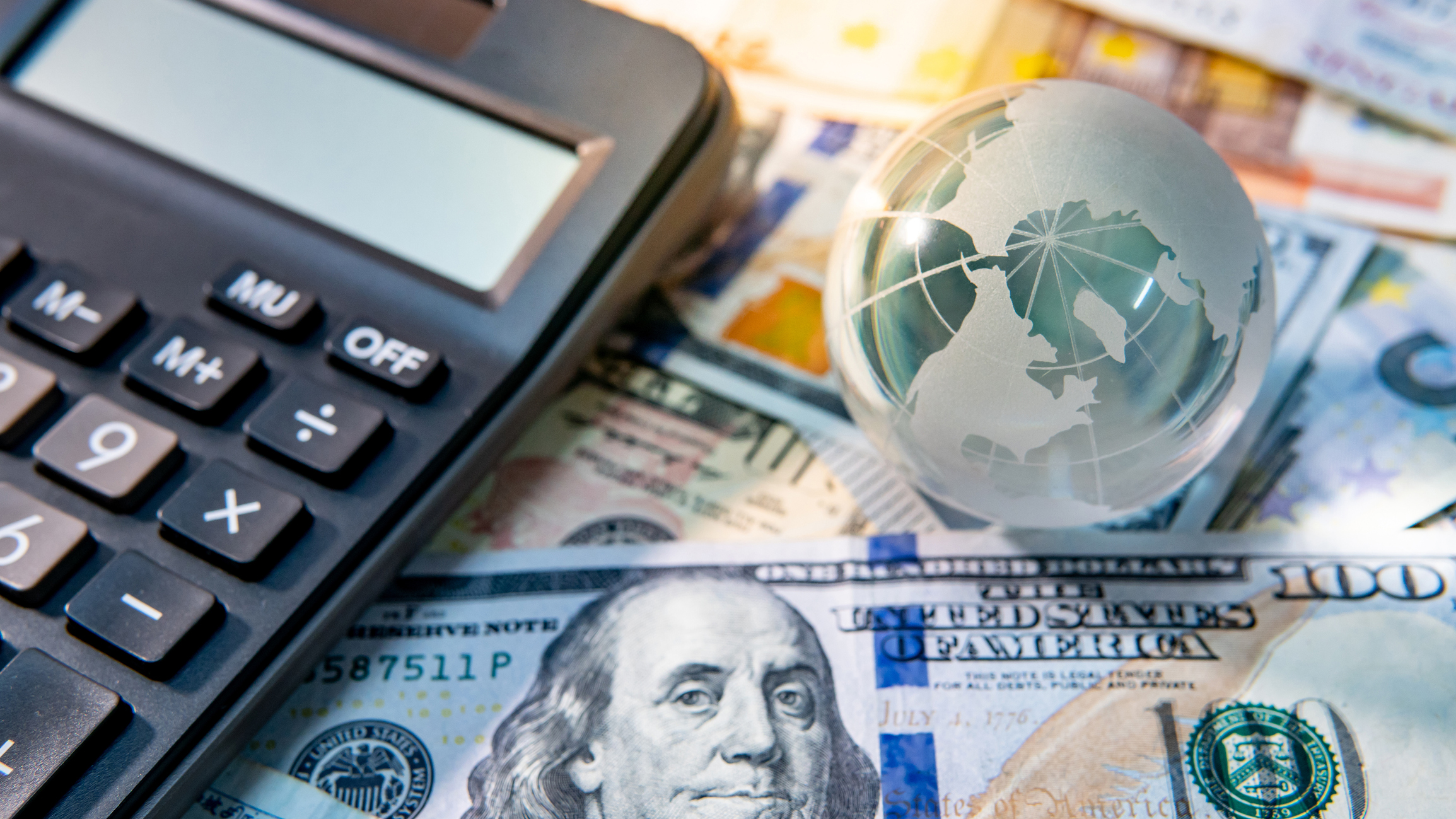 Closeup of calculator, globe and American currency