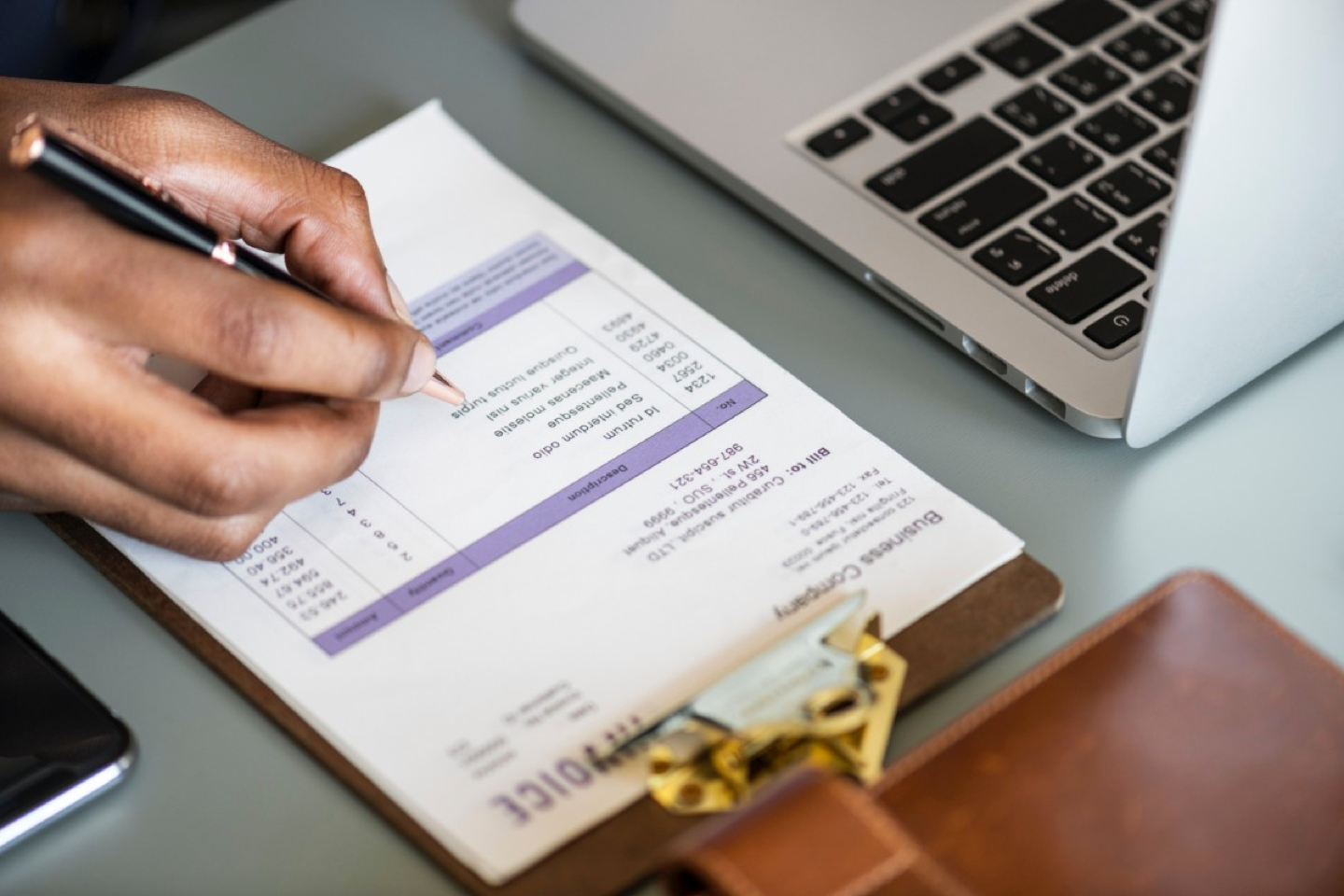 Close up of hand signing invoice