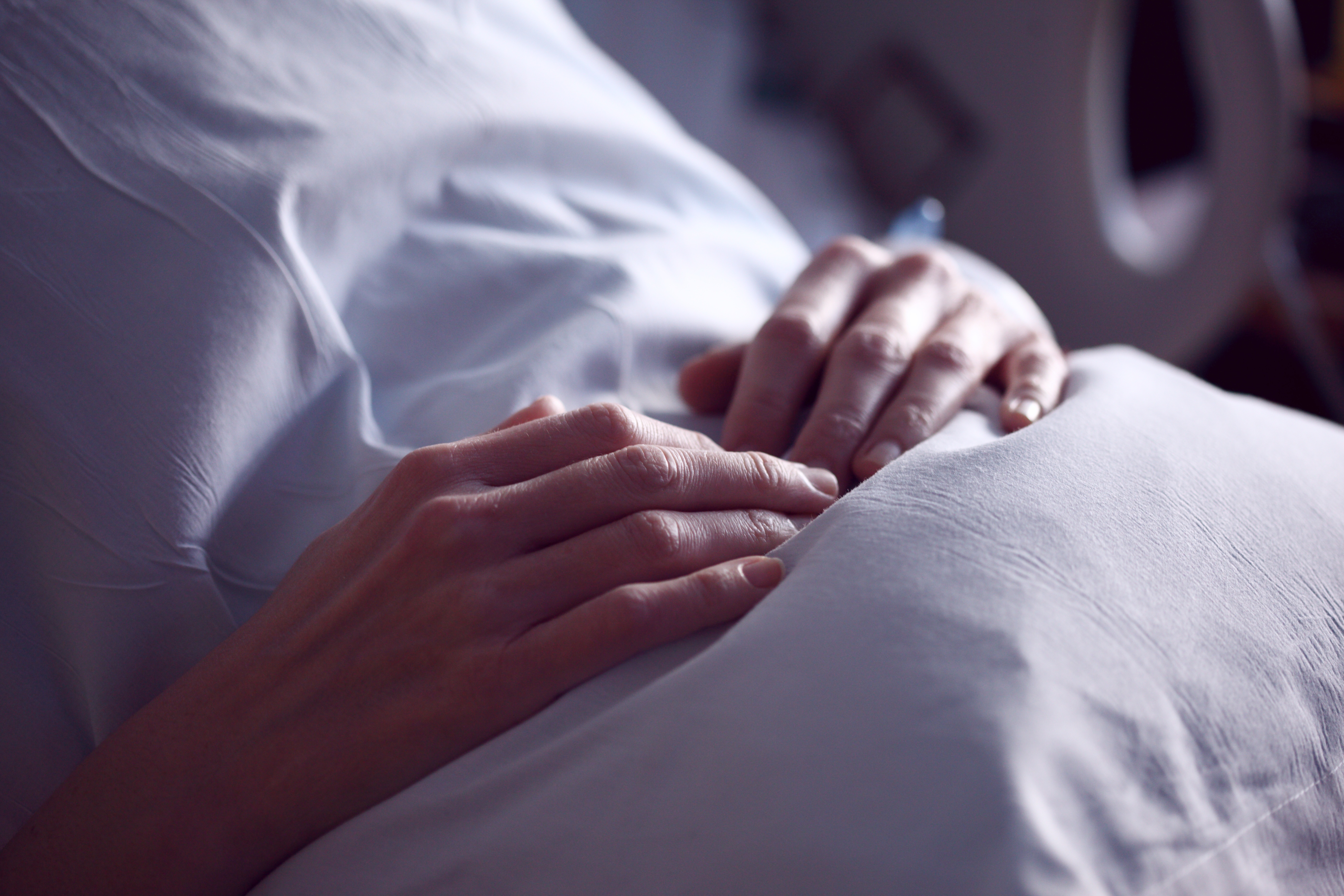 hands on covered stomach in hospital