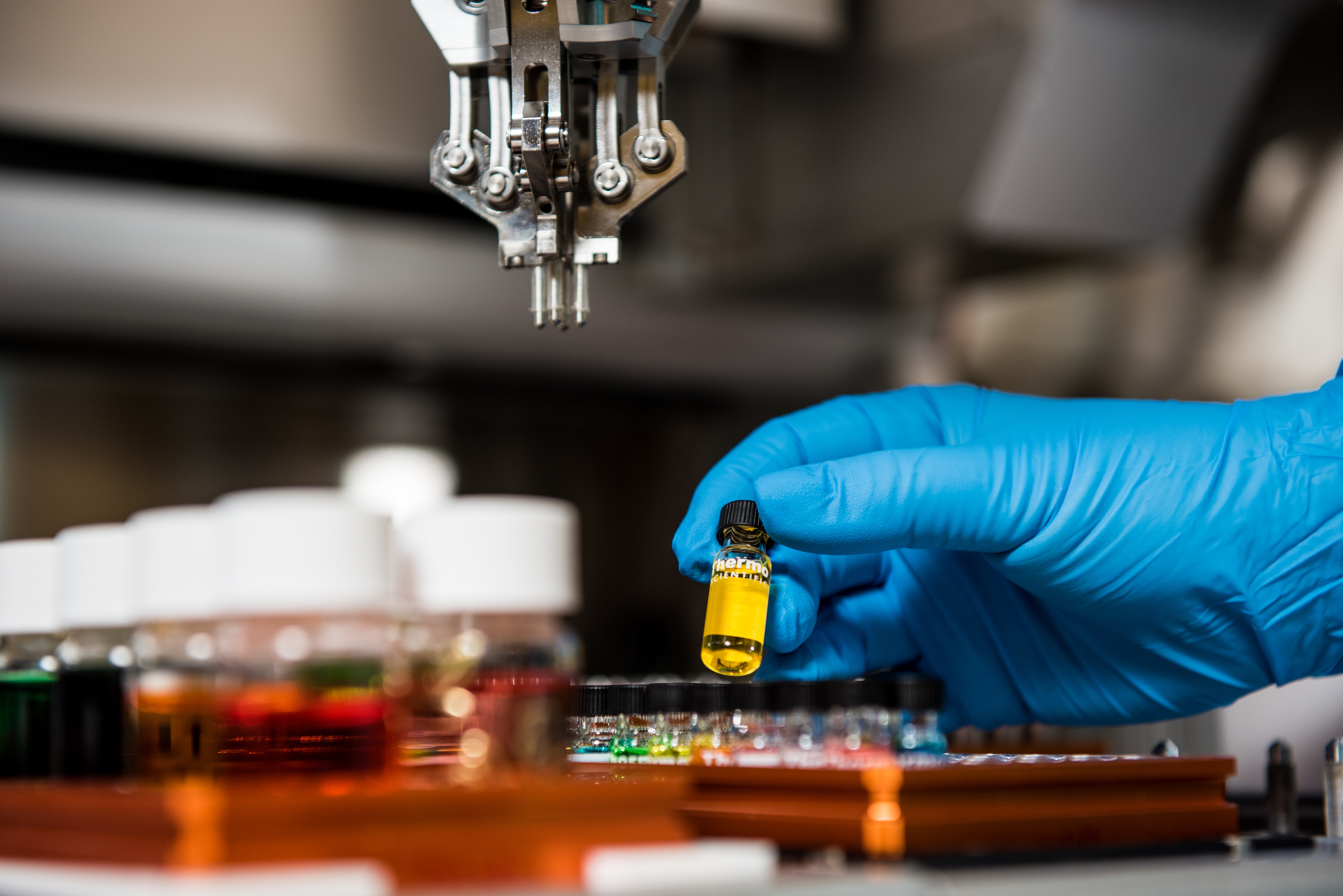 Close up of gloved hand handling chemicals in lab