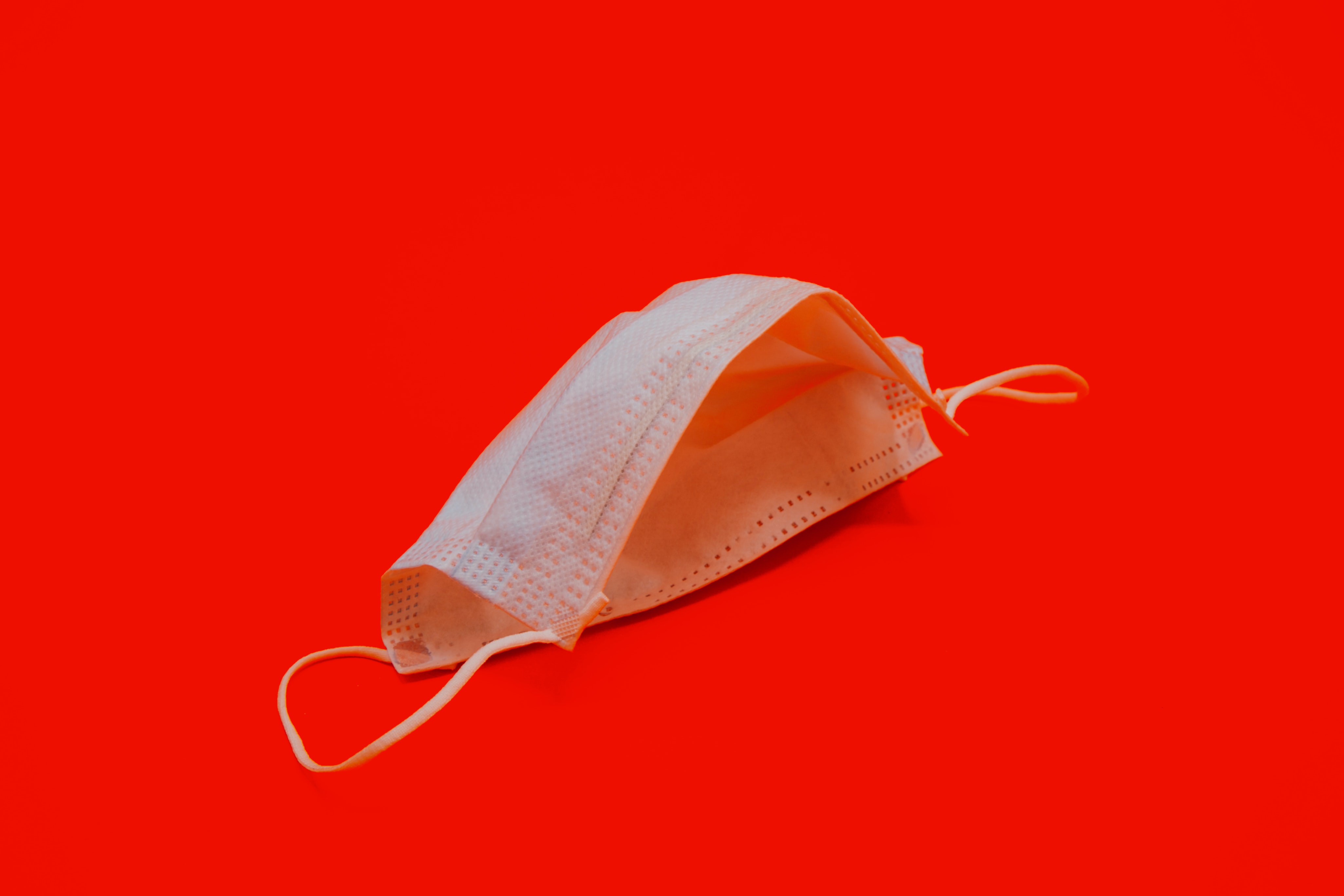 White face mask on red background